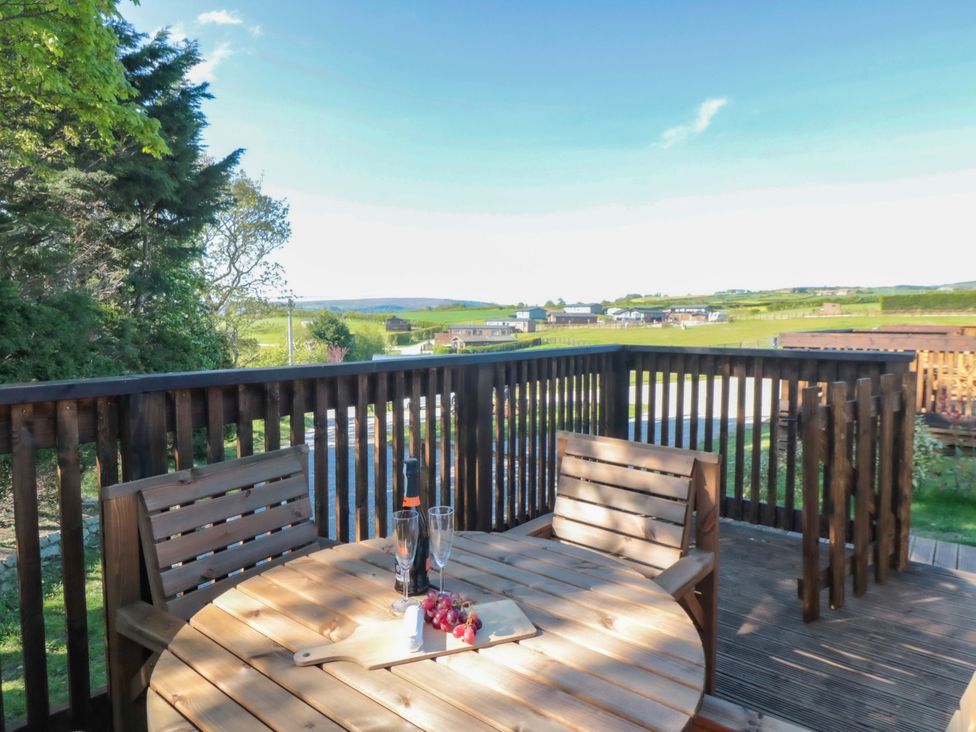 An outdoor seating area with a wooden table and chairs at Sage Sanctuary in Whitby