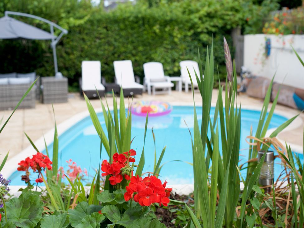A garden with a swimming pool and sun loungers at Apartment 2 in Torquay