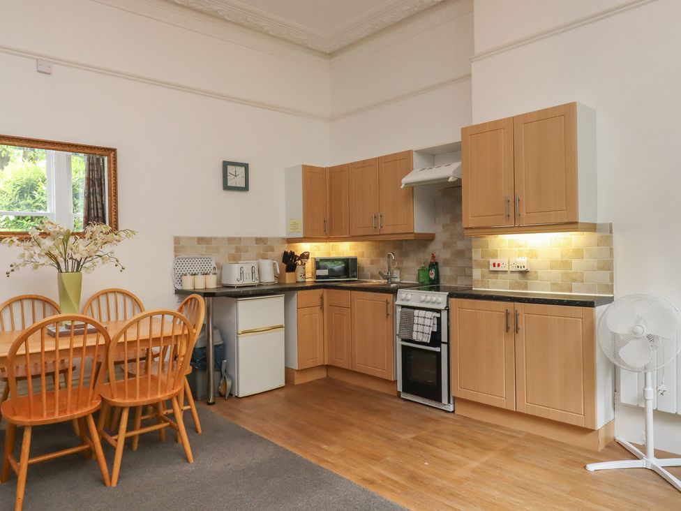 A kitchen with a dining table and chairs at Apartment 2 in Torquay