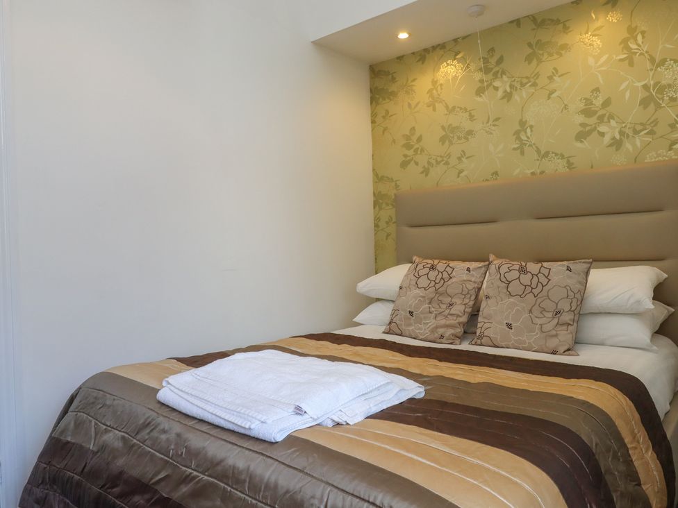 A bedroom with a bed and pillows at Apartment 2 in Torquay