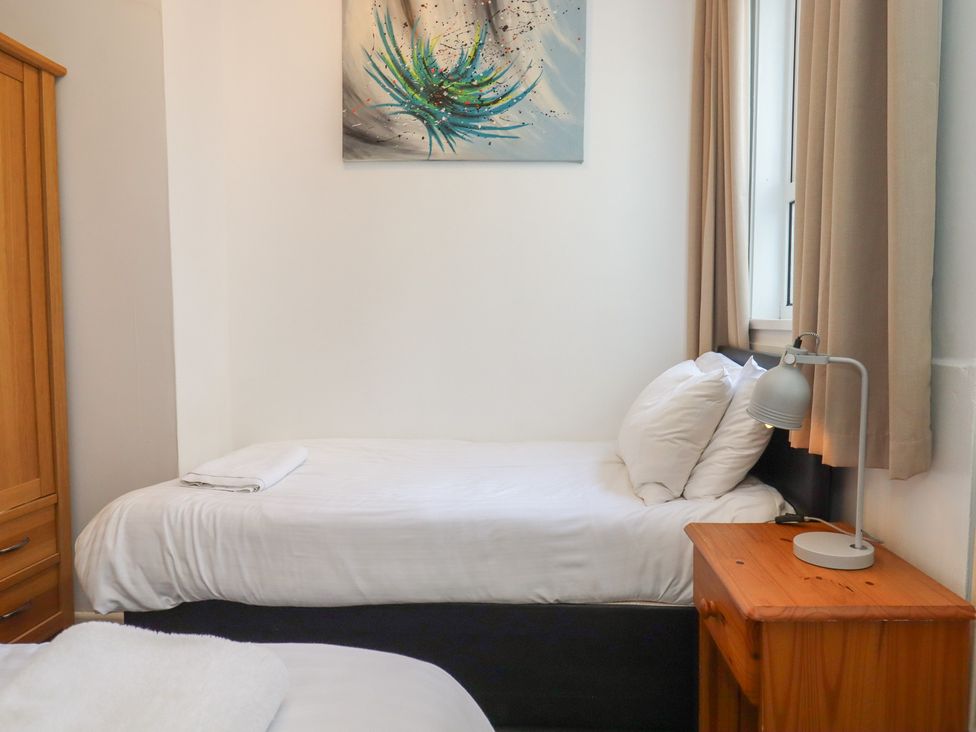 A bedroom with two beds and a lamp at Apartment 2 in Torquay