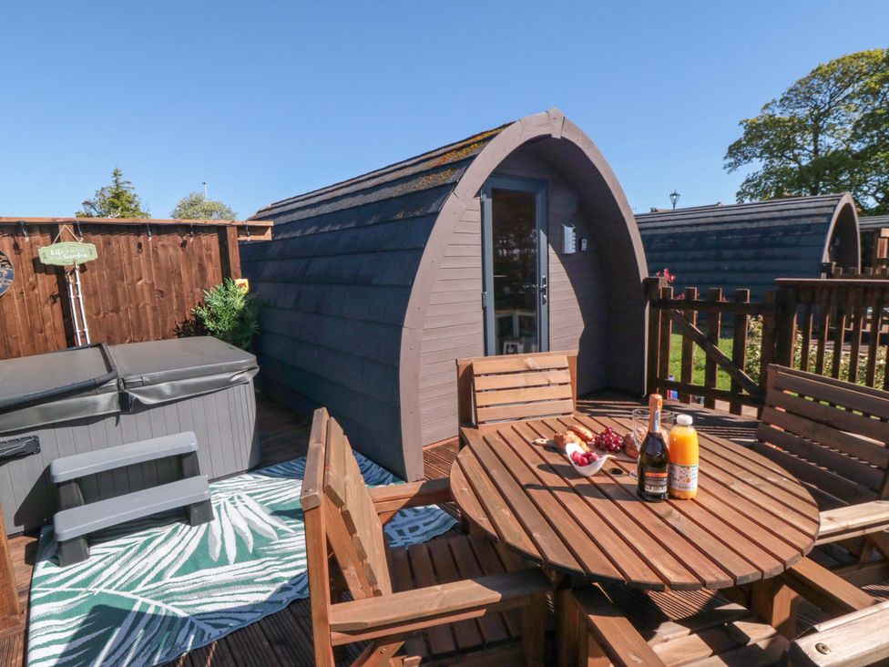 An outdoor area with a hot tub and table with drinks at Fern Folly in Whitby