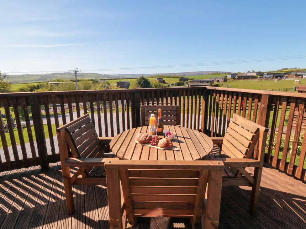An outdoor seating area with a wooden table and chairs at Fern Folly in Whitby