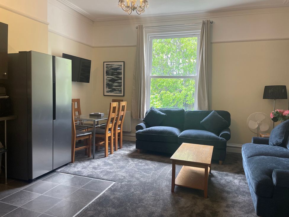 A living room with a sofa and dining area at Apartment 5 in Torquay