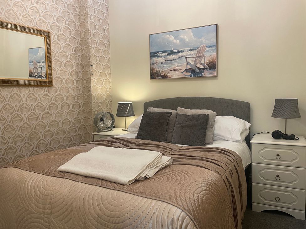 A bedroom with a bed and mirror at Apartment 5 in Torquay