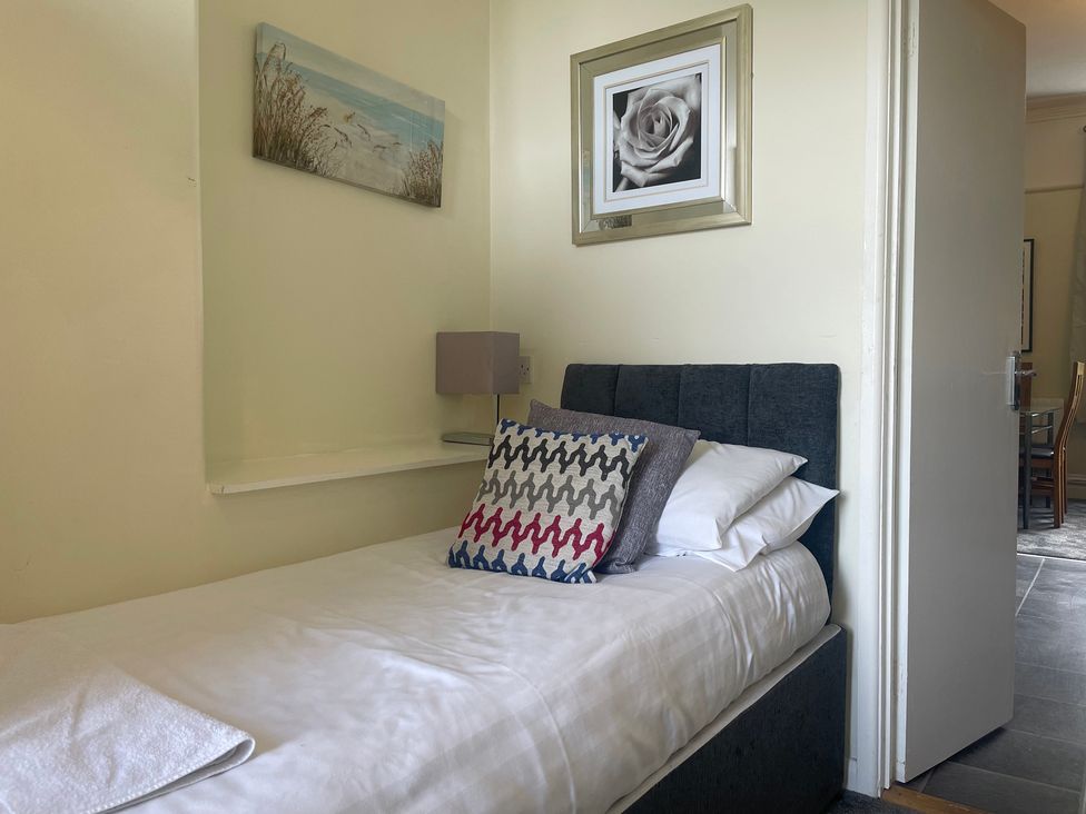 A bedroom with a single bed and decorative items at Apartment 5 in Torquay