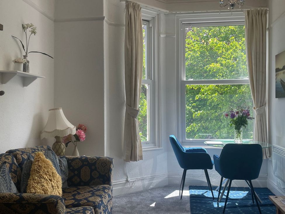 A living room with a sofa and a dining area at Apartment 6 Torquay