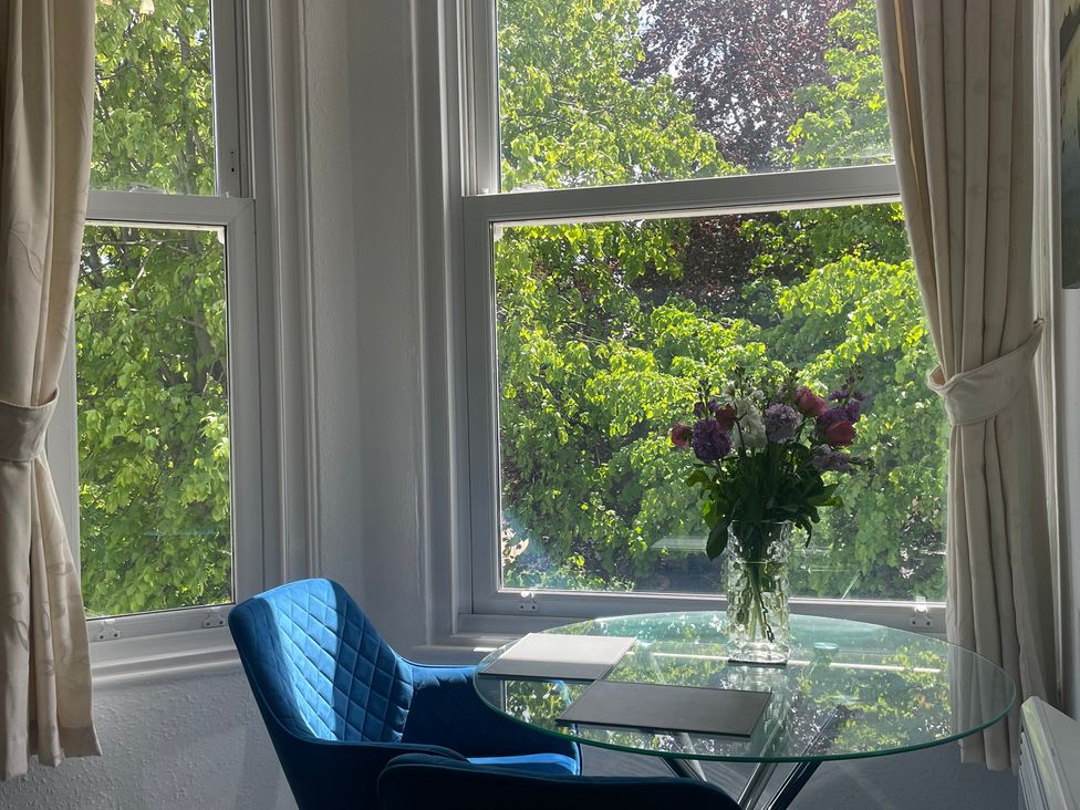 A dining area with a table and flowers at Apartment 6 in Torquay