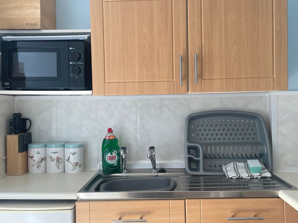 A kitchen with a sink and microwave at Apartment 6 in Torquay