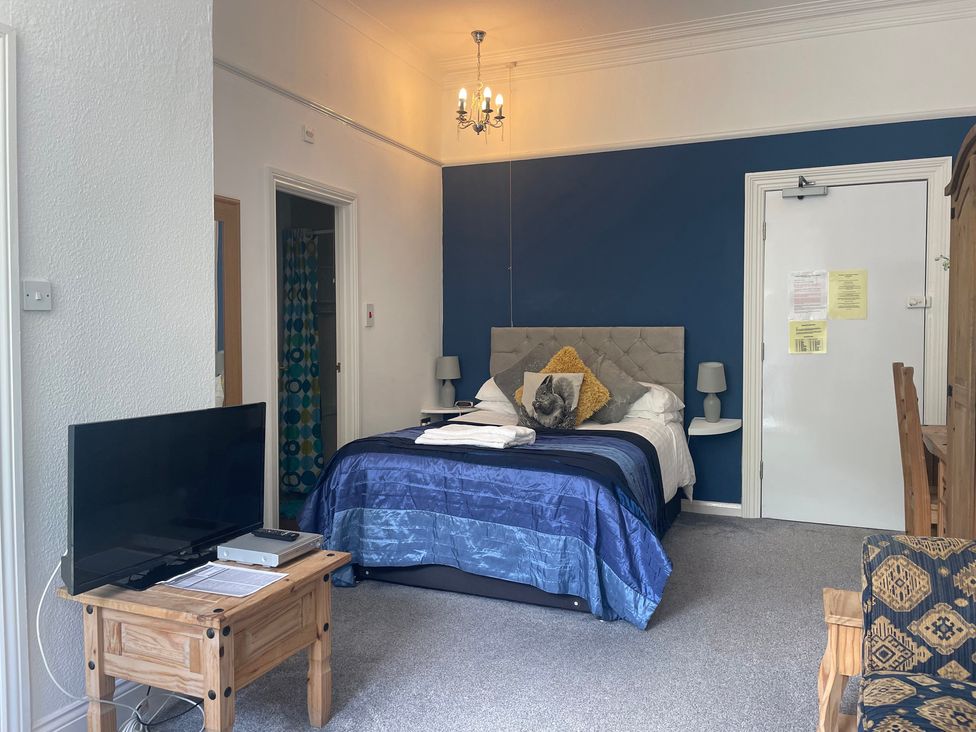 A studio with a bed, television, and dining area at Apartment 6 in Torquay