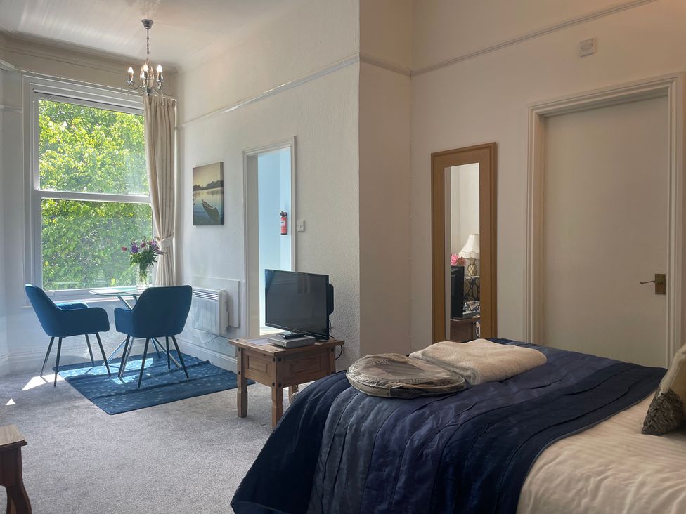 A bedroom with a bed and seating area at Apartment 6 in Torquay