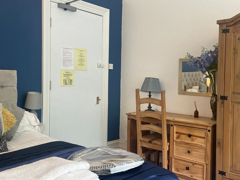A bedroom with a bed and desk at Apartment 6 in Torquay