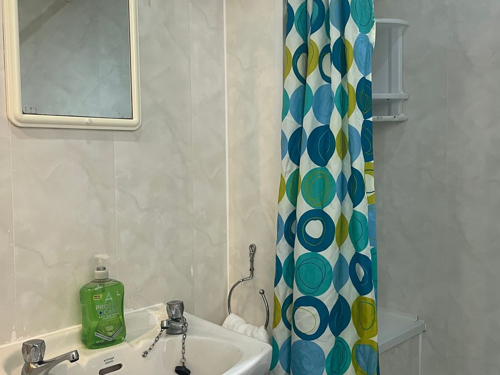 A bathroom with a sink and shower curtain at Apartment 6 in Torquay