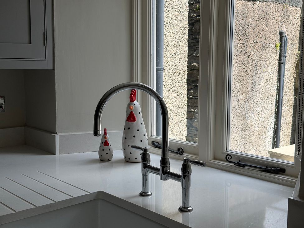 A kitchen sink with a faucet and decorative figurines at La'al Kirkstone Brow in Ambleside