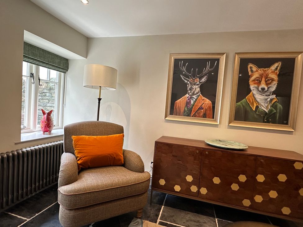 A snug with an armchair and paintings at La'al Kirkstone Brow in Ambleside