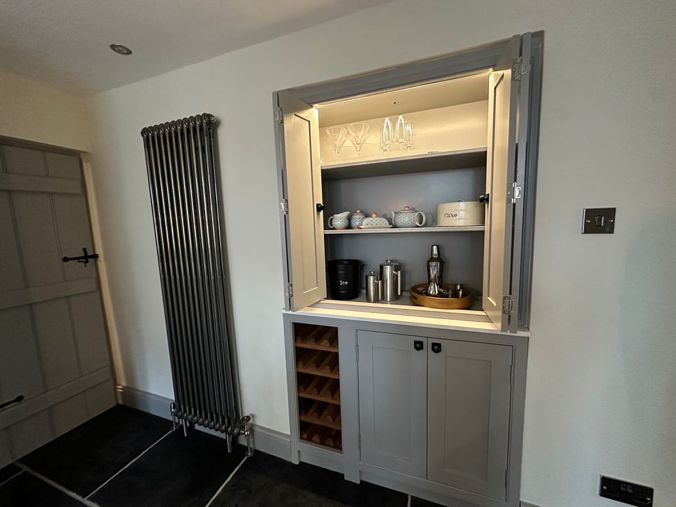 A cupboard with glasses and teapots in the kitchen at La'al Kirkstone Brow Ambleside