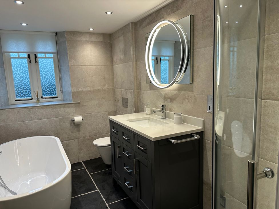 A bathroom with a bathtub, vanity, and shower at La'al Kirkstone Brow in Ambleside