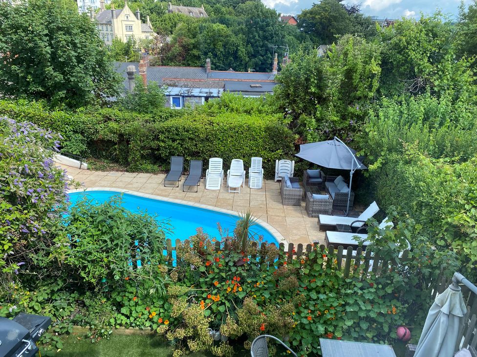 An outdoor area with a swimming pool and sun loungers at Apartment 10 in Torquay