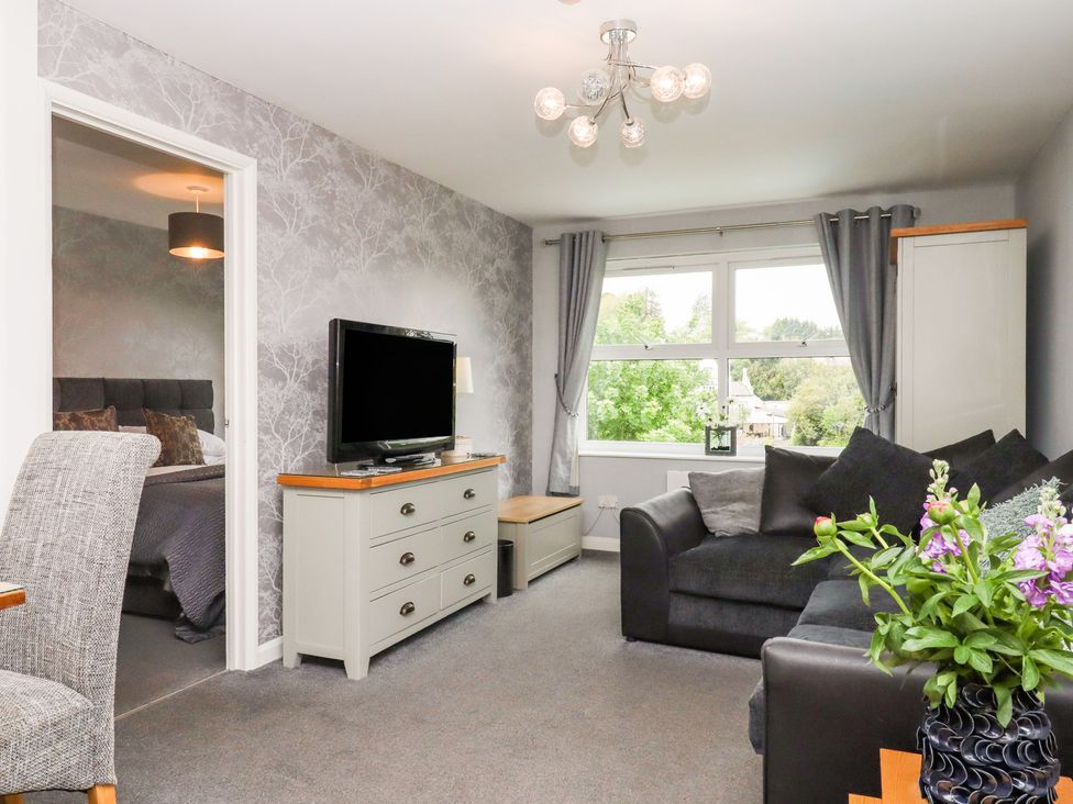 A living room with a television and sofa at Apartment 10 in Torquay