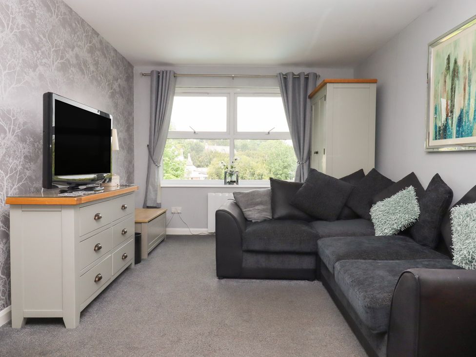 A living room with a television and sofa at Apartment 10 in Torquay