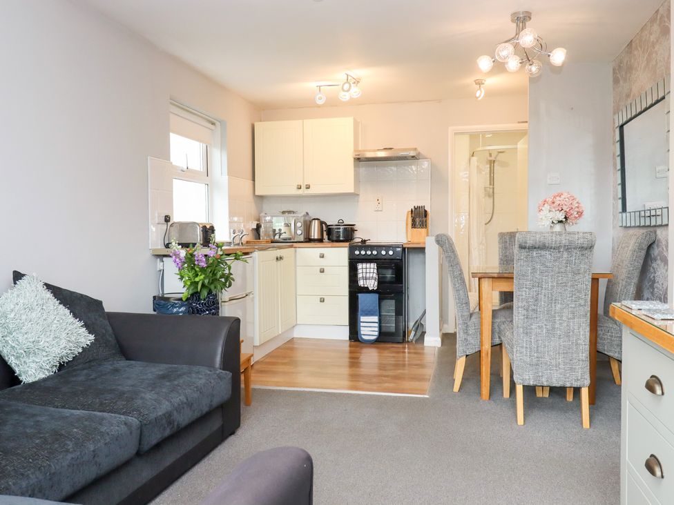 A kitchen with a dining table and sofa at Apartment 10 in Torquay