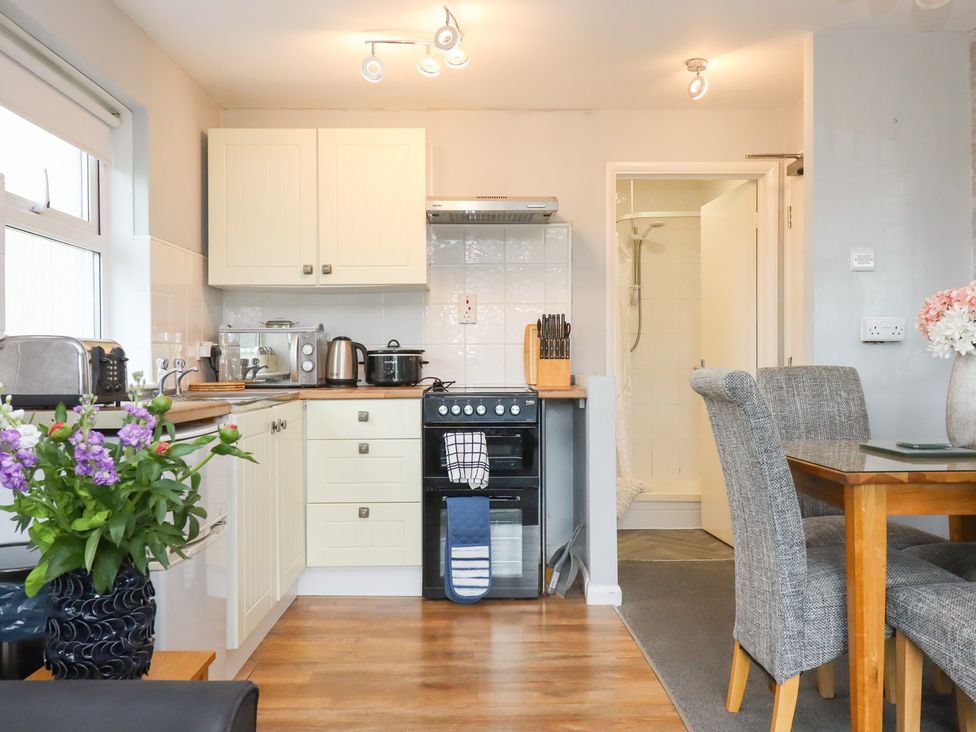 A kitchen with appliances and dining area at Apartment 10 in Torquay