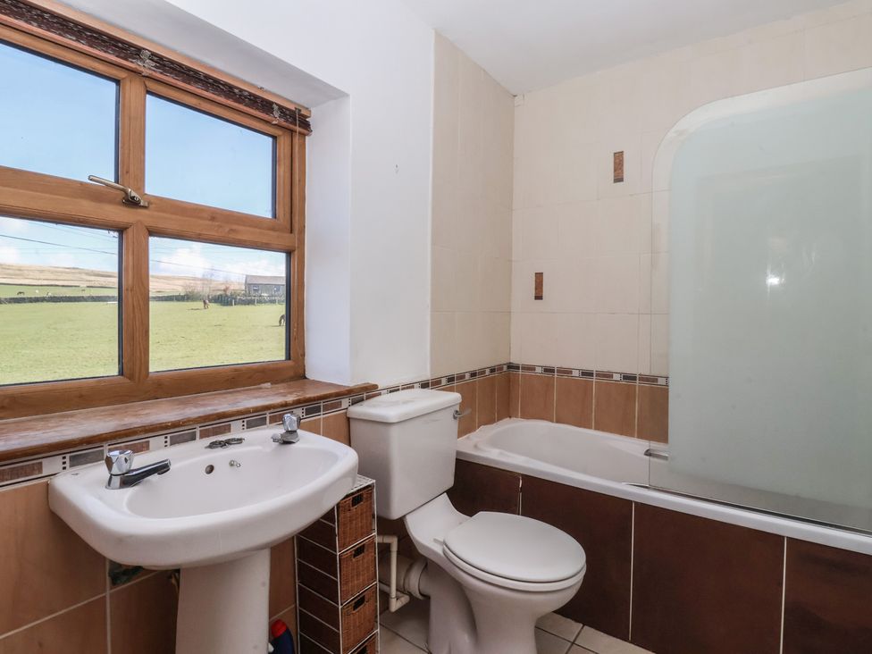 A bathroom with a sink, toilet, bathtub and shower at 1 Upper Austby Farm Cottage Ilkley