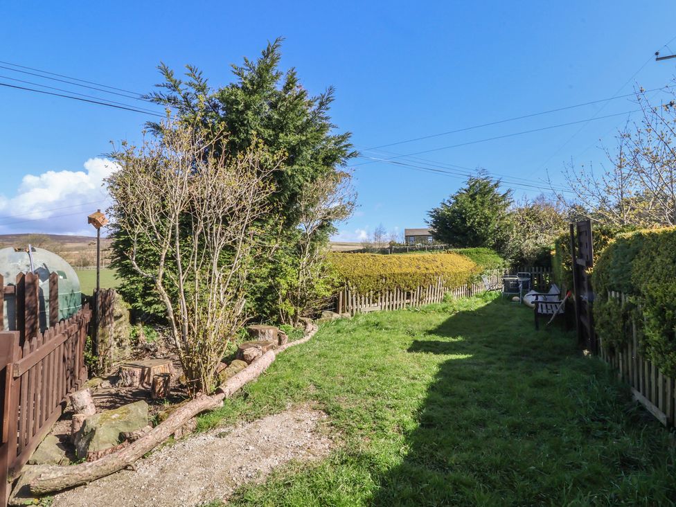 A garden with trees and a pathway at 1 Upper Austby Farm Cottage in Ilkley