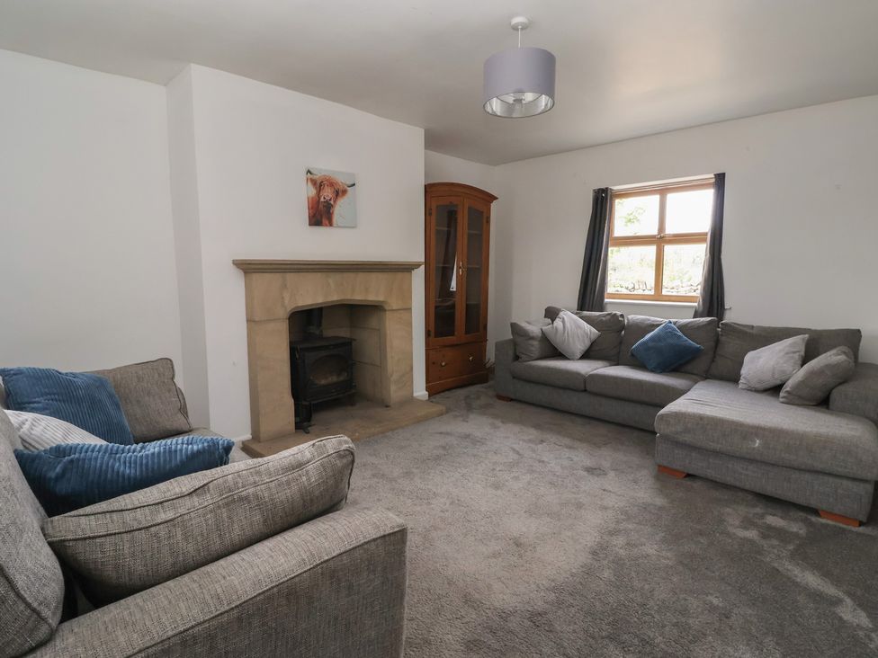 A living room with a fireplace and sofas at 1 Upper Austby Farm Cottage Langbar near Ilkley