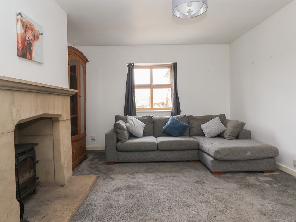 A living room with a sofa and fireplace at 1 Upper Austby Farm Cottage Langbar near Ilkley