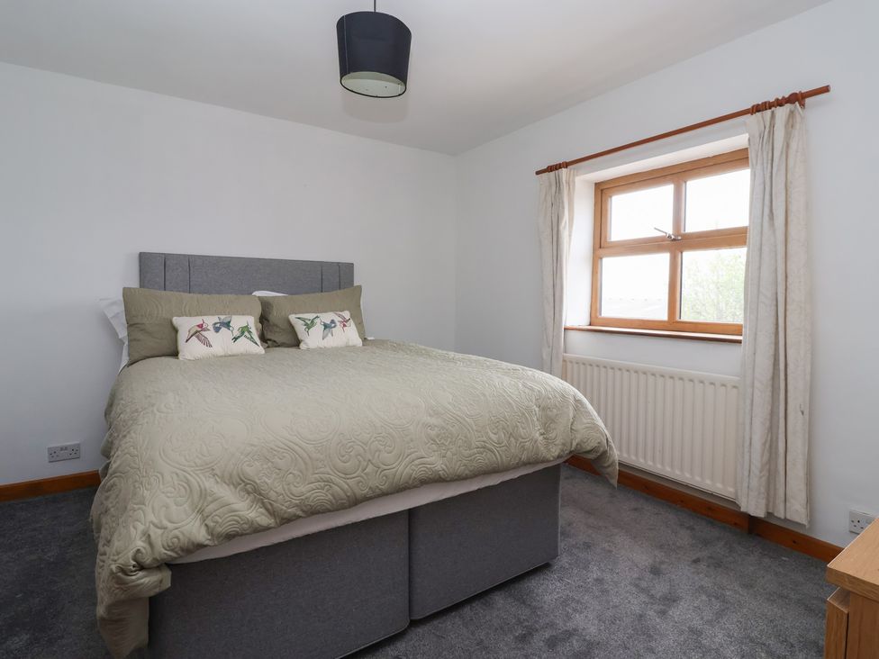 A bedroom with a bed and window at 1 Upper Austby Farm Cottage Langbar near Ilkley