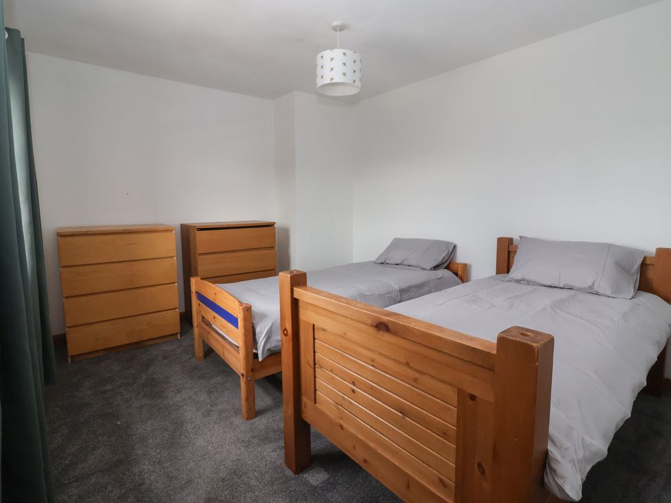 A bedroom with two beds and a dresser at 1 Upper Austby Farm Cottage in Langbar near Ilkley