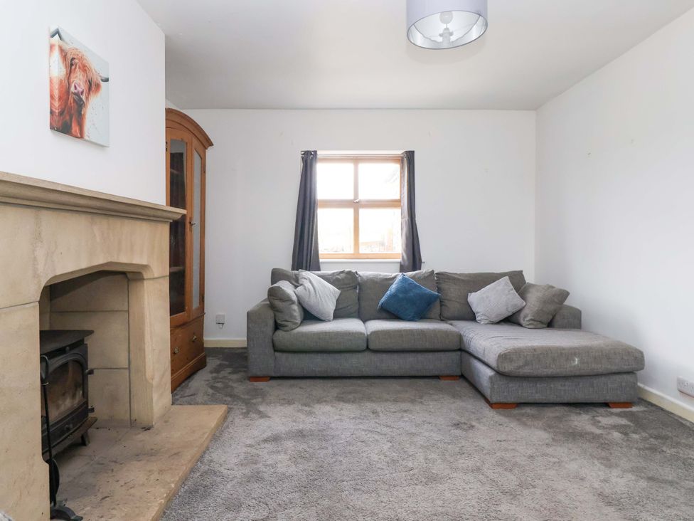 A living room with a sofa and a fireplace at 1 Upper Austby Farm Cottage in Langbar near Ilkley