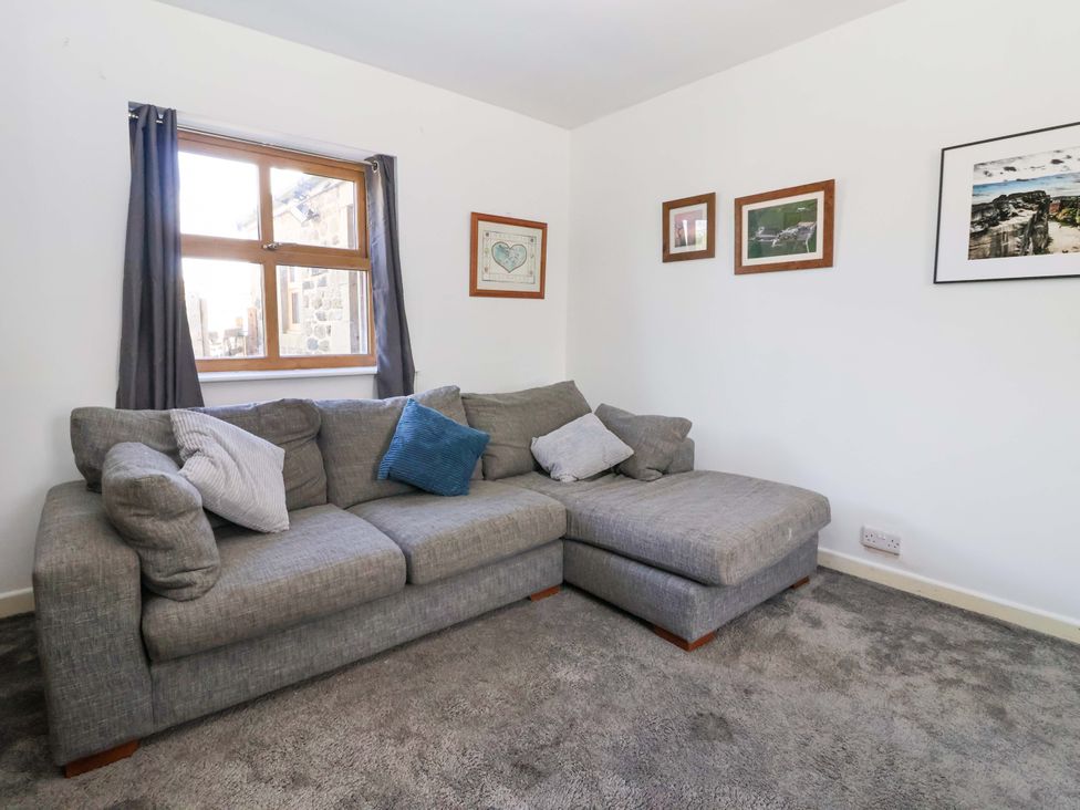 A living room with a sofa near a window at 1 Upper Austby Farm Cottage Langbar near Ilkley