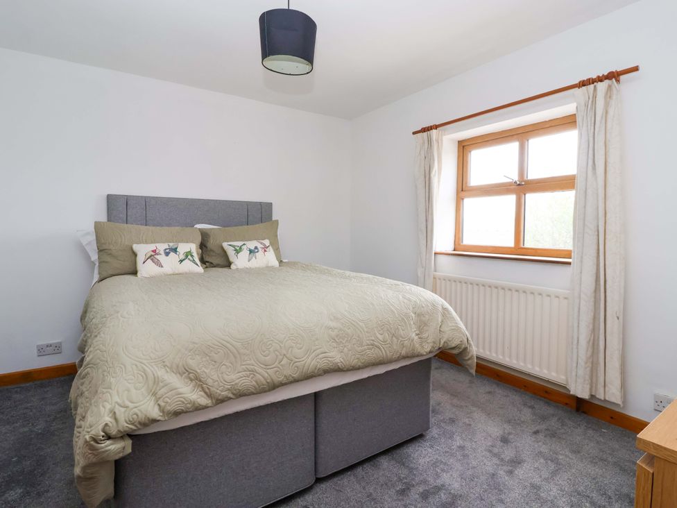 A bedroom with a bed and window at 1 Upper Austby Farm Cottage in Langbar near Ilkley