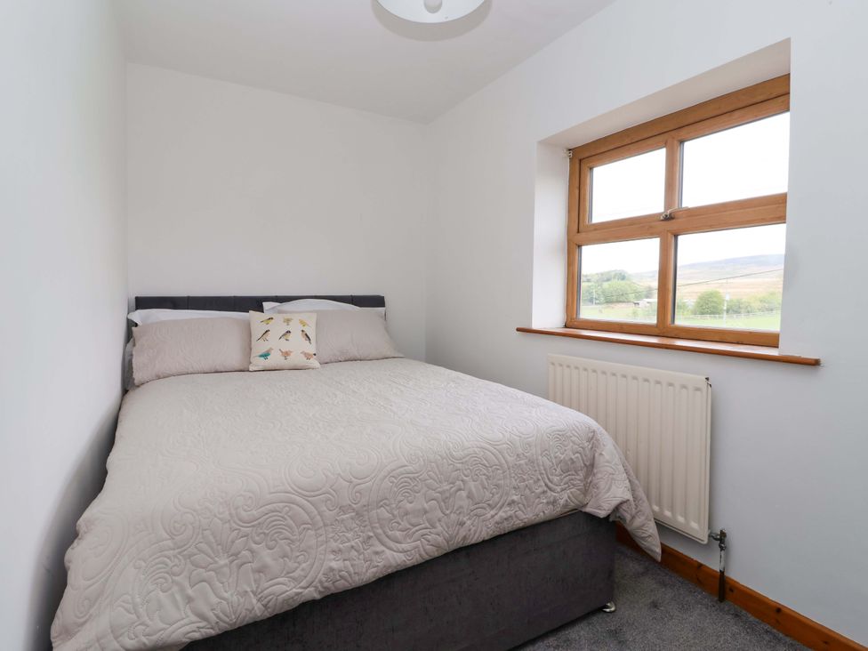 A bedroom with a bed and a window at 1 Upper Austby Farm Cottage Langbar near Ilkley