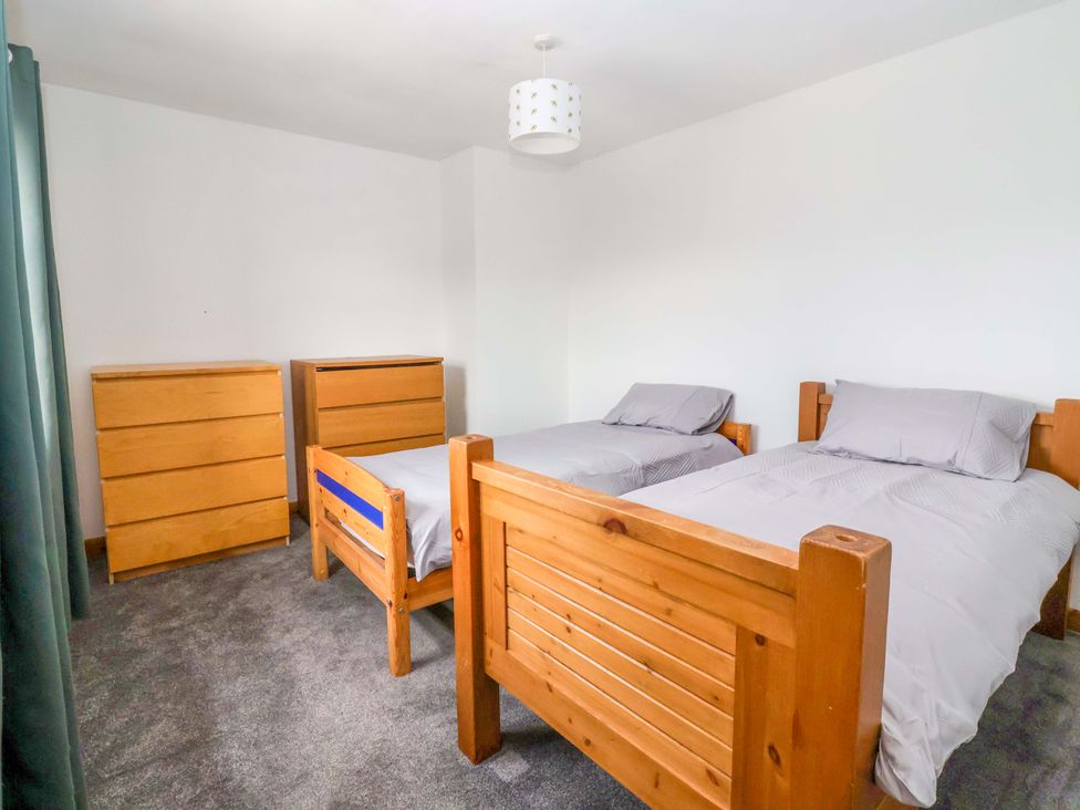 A bedroom with two beds and a dresser at 1 Upper Austby Farm Cottage in Langbar near Ilkley