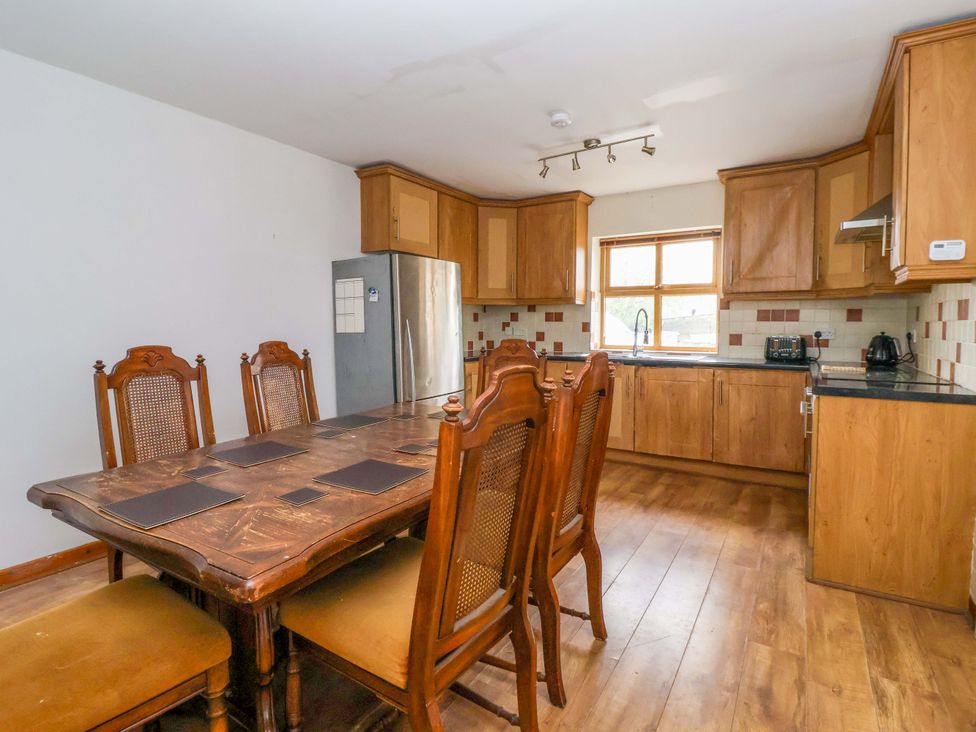 A kitchen with a dining table and chairs at 1 Upper Austby Farm Cottage in Langbar near Ilkley