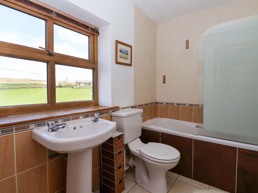 A bathroom with a bath tub and sink at 1 Upper Austby Farm Cottage Langbar near Ilkley