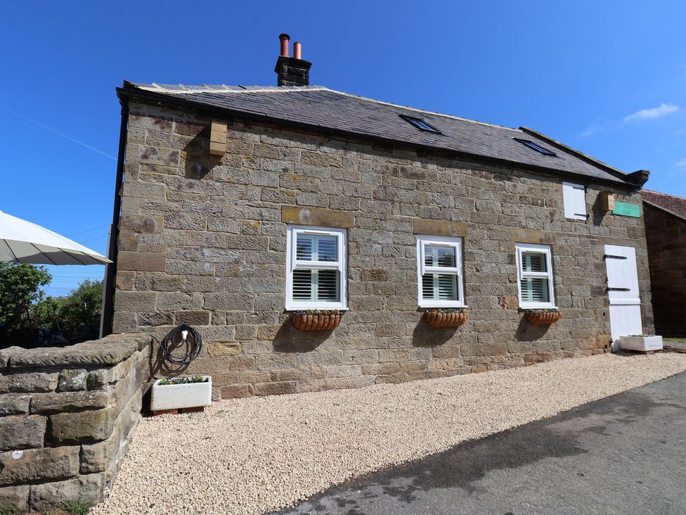 A stone building with gravel surface and windows at Little Holm Garth