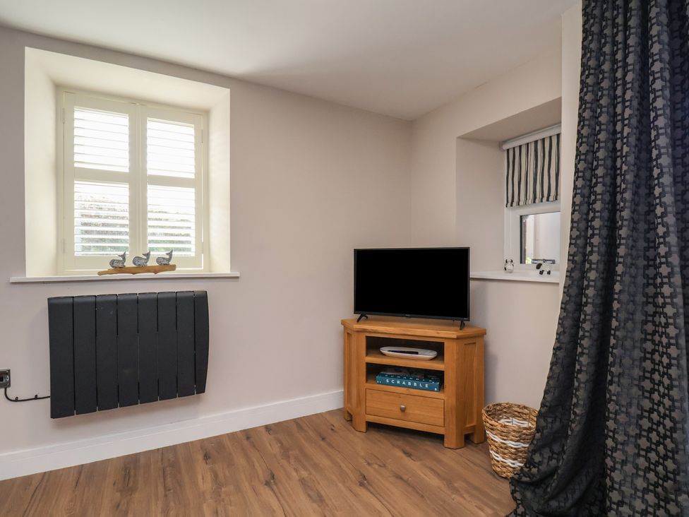 A living room with a television and window at Little Holm Garth