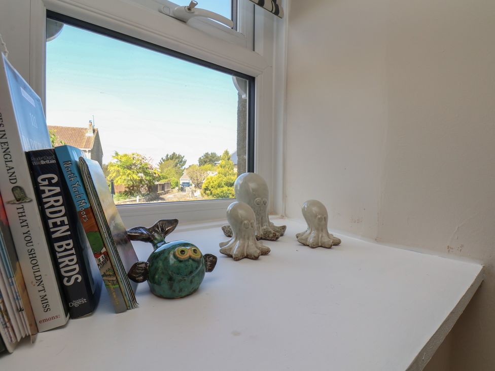 A windowsill with books and decorative items at Little Holm Garth in 