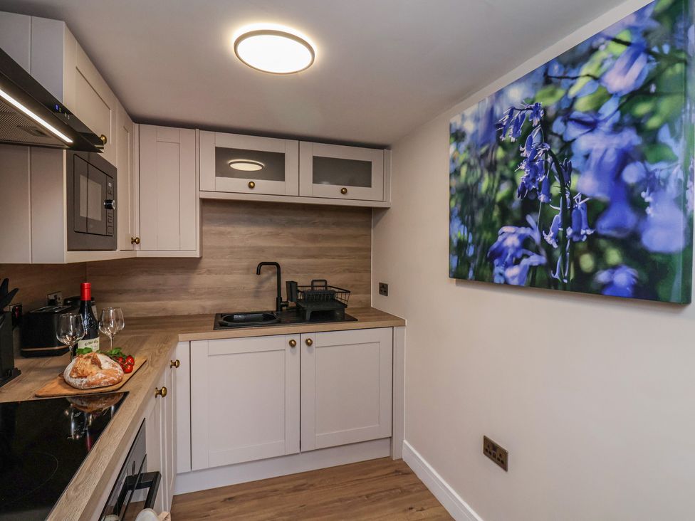 A kitchen with microwave, sink, and cooking surface at Little Holm Garth 