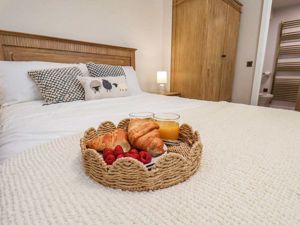 A bedroom with a bed and breakfast items on a tray at Little Holm Garth