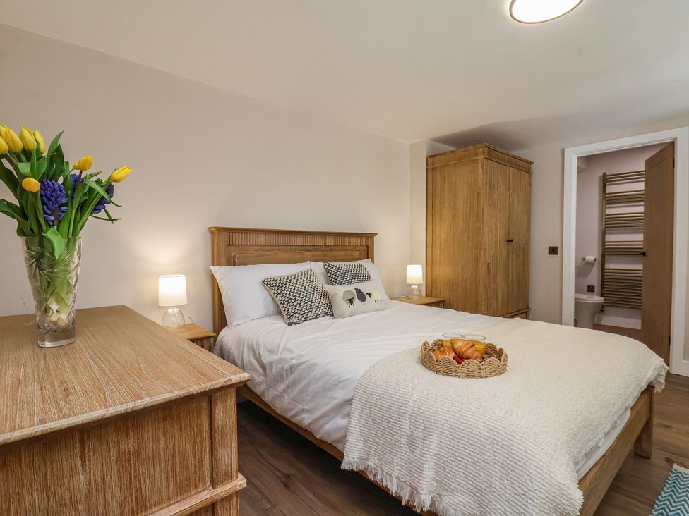 A bedroom with a bed and a wardrobe at Little Holm Garth