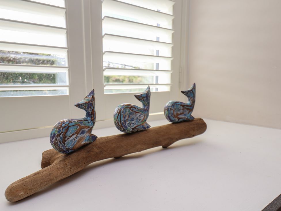 Three decorative figures on driftwood at Little Holm Garth in 