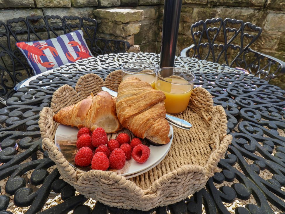 A croissant fruit and orange juice on a table at Little Holm Garth