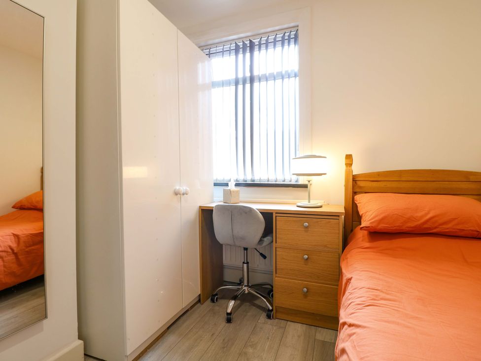 A bedroom with a bed, desk, and wardrobe at 57 Abbey Street