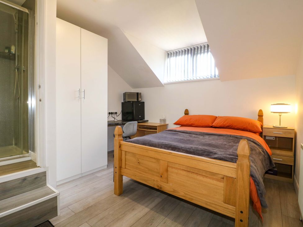 A bedroom with a bed and computer workstation at 57 Abbey Street