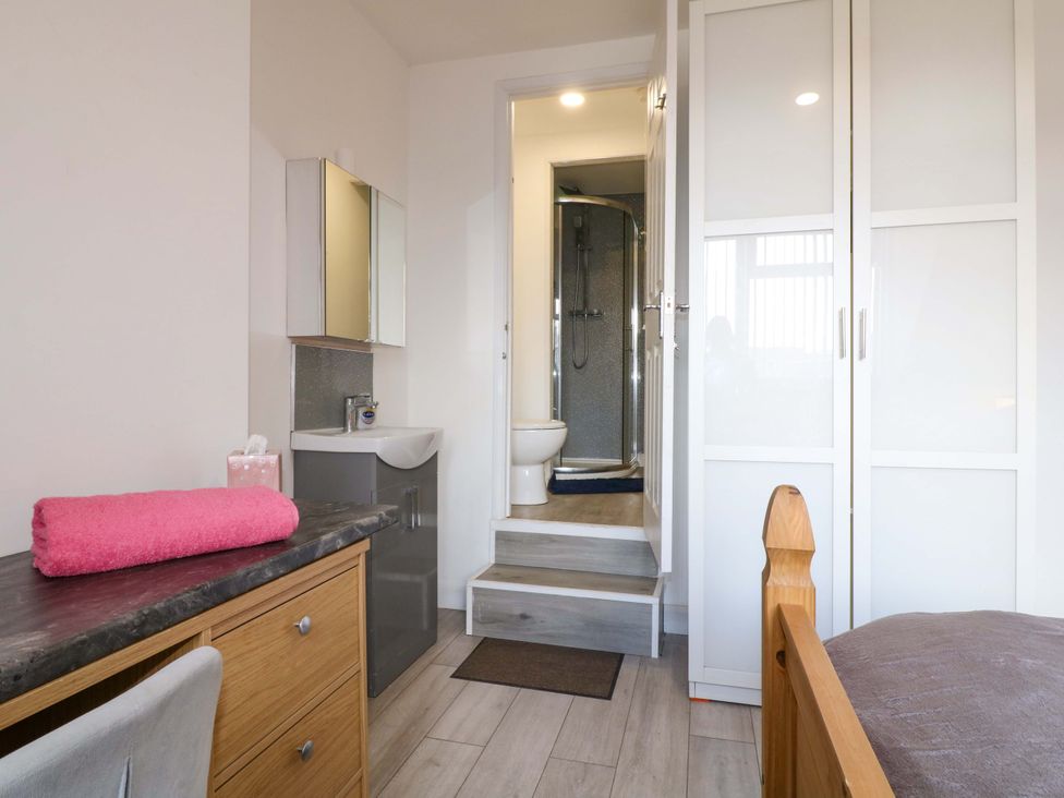 A bedroom with a desk and attached bathroom at 57 Abbey Street